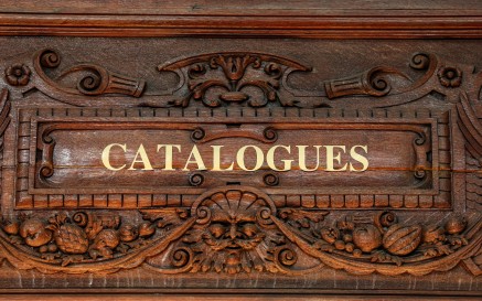 Close up of text written above a doorway reading 'Catalogues' 