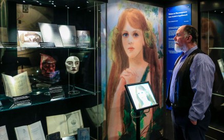 A well-dressed man looks at a display case full of WB Yeats exhibition material 